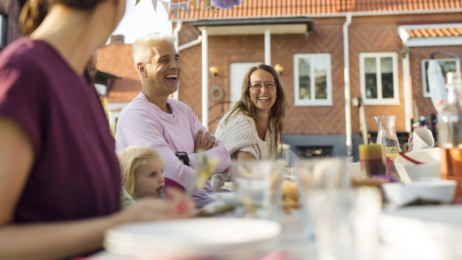 Rachat de crédit propriétaire : une fête de famille dans le jardin d'un quartier résidentiel