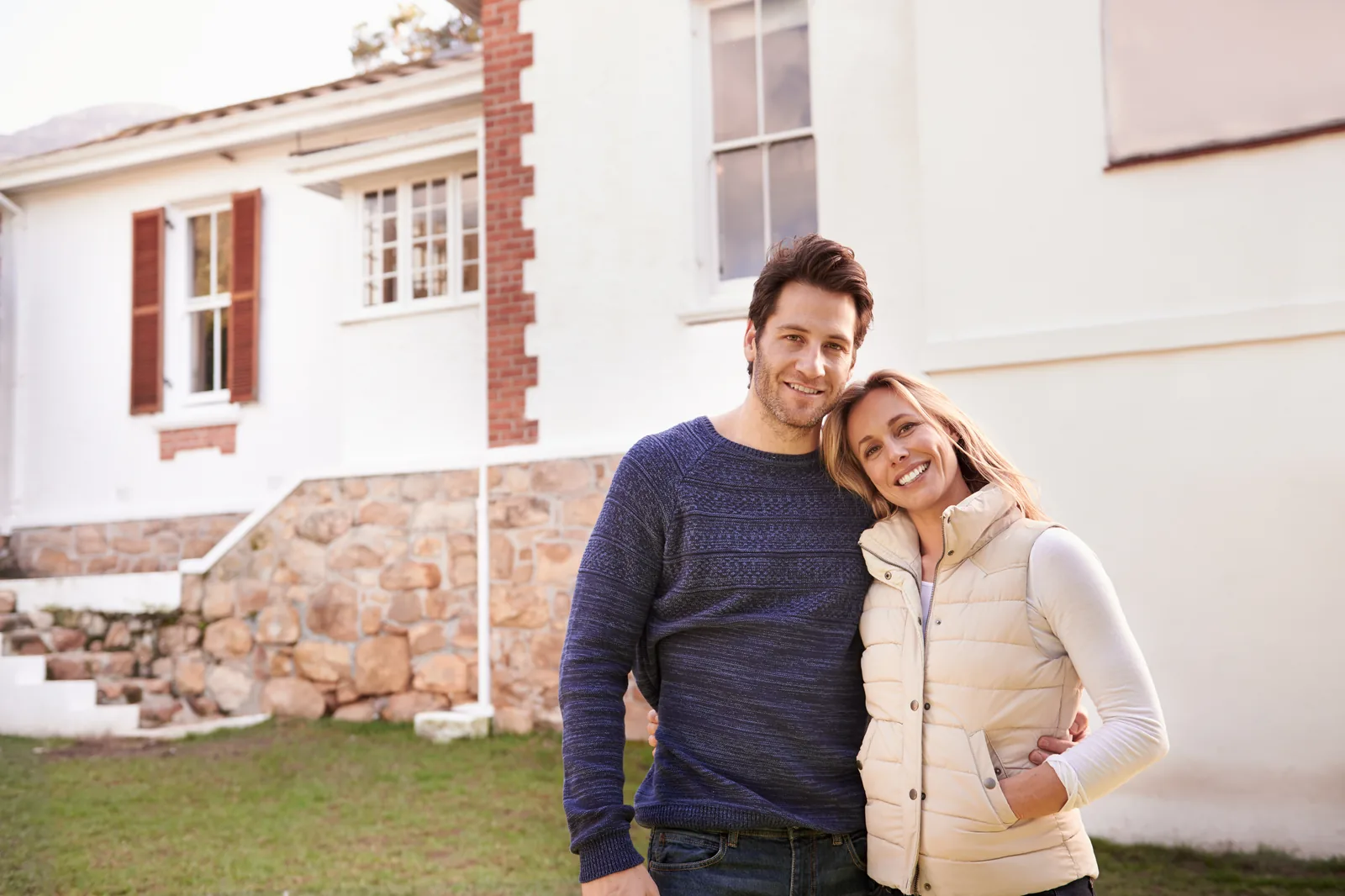 Rachat crédit immobilier : un couple devant la maison qu'il vient d'acheter