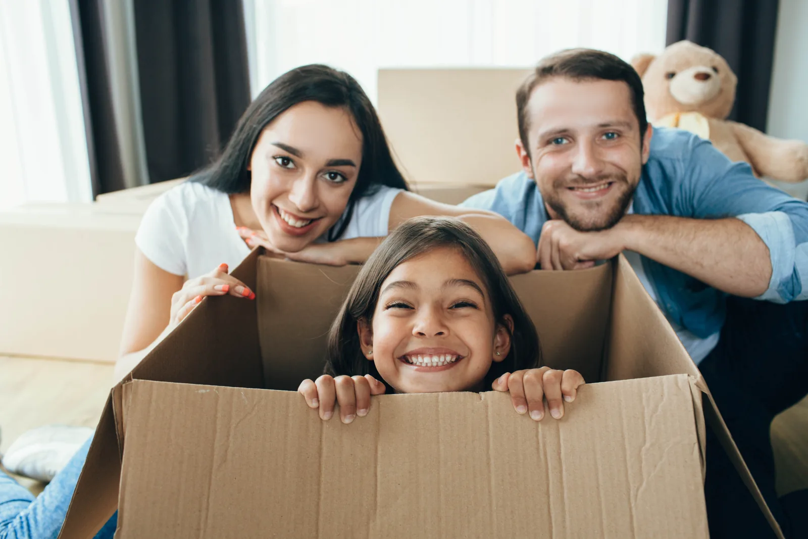 Rachat de crédits le moins cher : une famille souriante au milieu de ses cartons d'emménagement